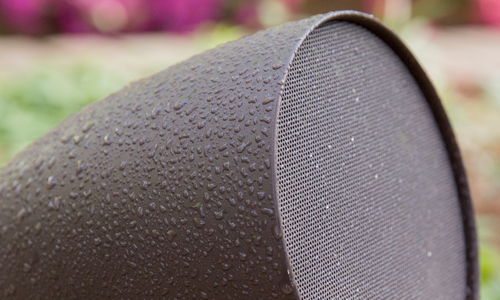 Zoomed in view of satellite speaker with water droplets on it