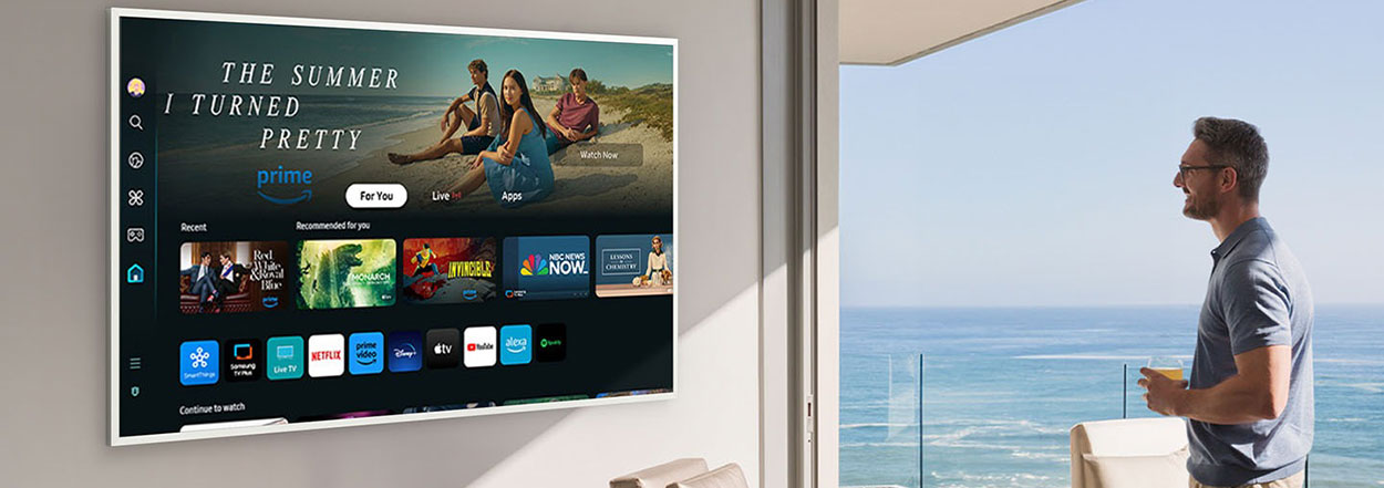 A man is looking at various entertainment options offered on Samsung Tizen OS on The Frame TV.